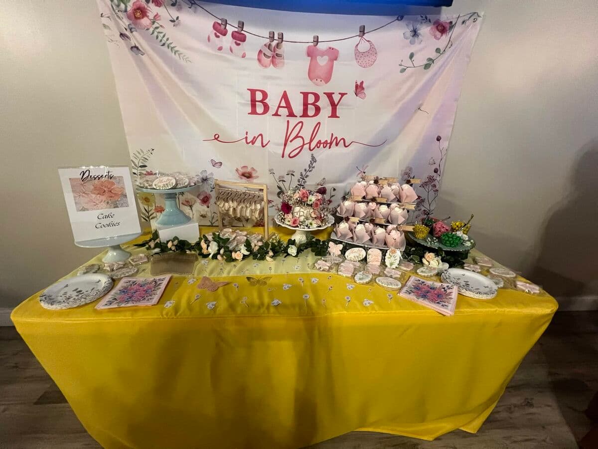 Baby in Bloom dessert table with cookies, cake stands, and floral backdrop