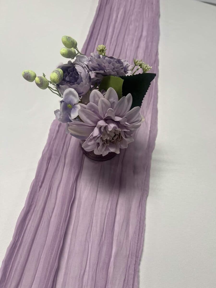 Lavender gauze runner with purple floral centerpiece arrangement