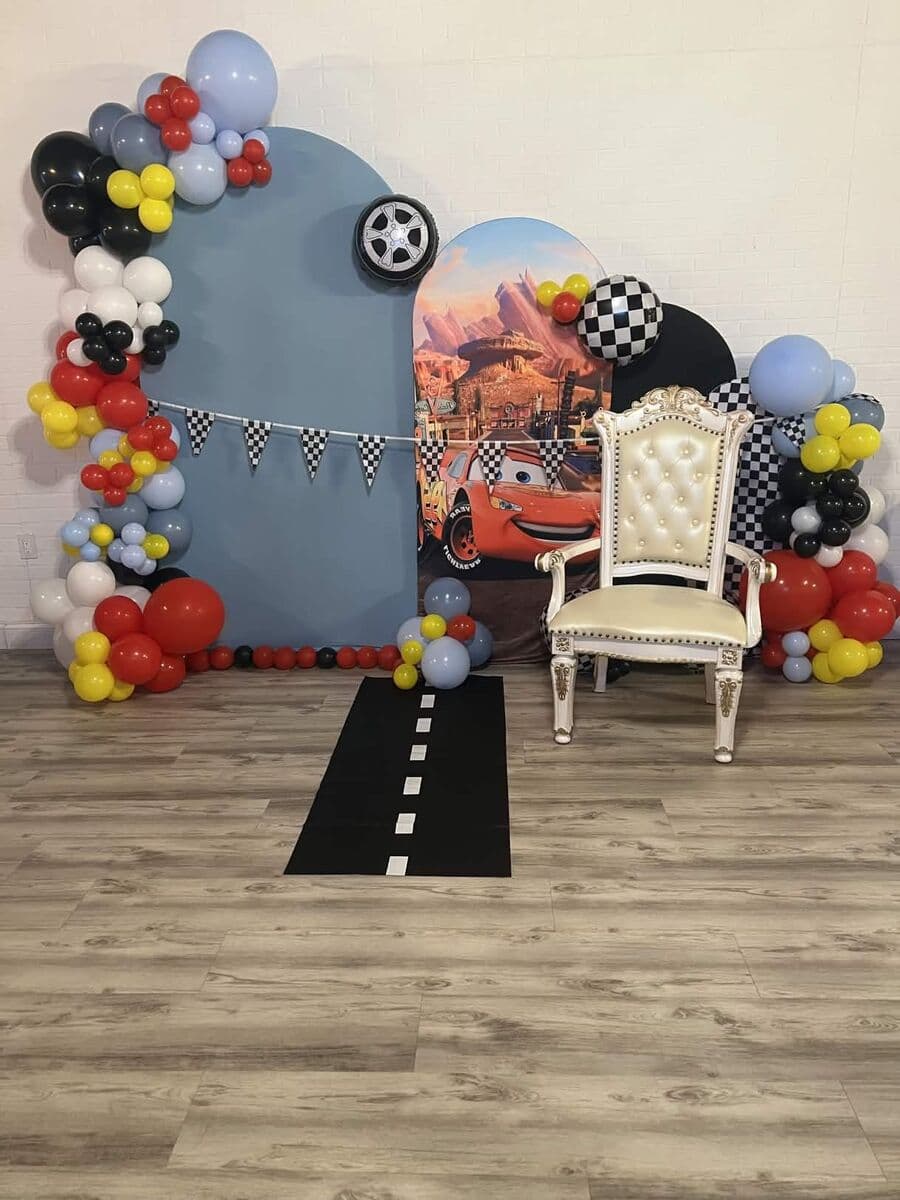 Racing Cars birthday theme with checkered balloons, throne chair, and road runner at LSC Event Space