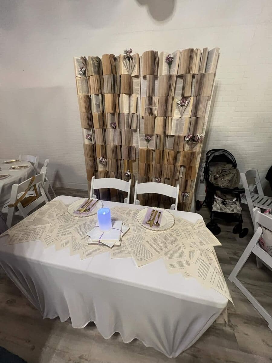 Vintage Books baby shower theme with folded book backdrop and literary table setting