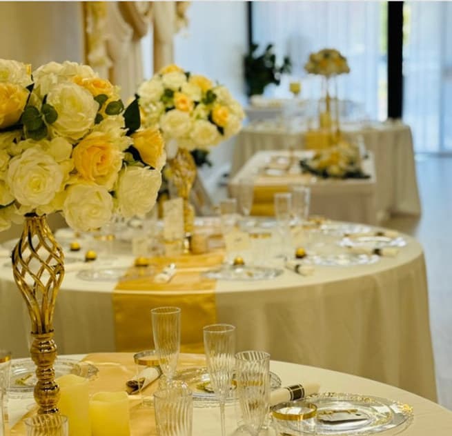 Wedding reception tables with ivory linens and gold centerpieces at LSC Event Space in New Port Richey